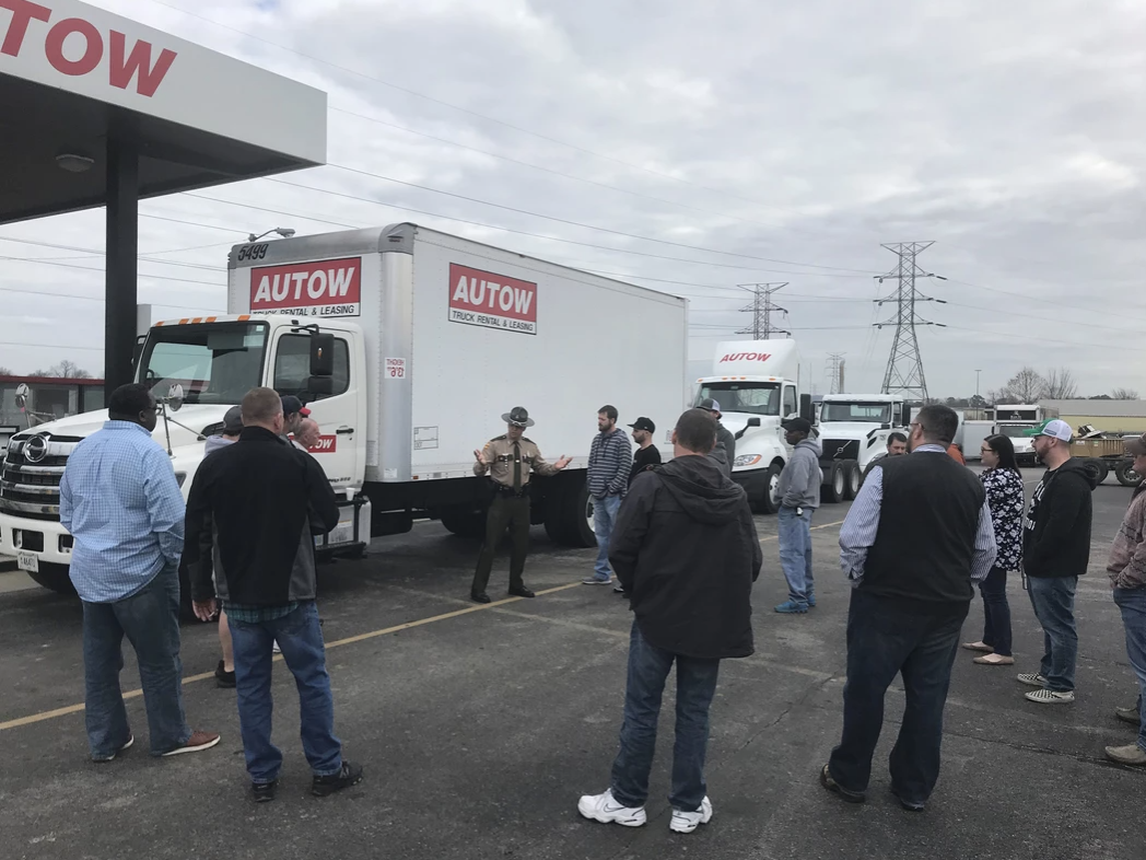 a group of people standing in a parking lot a group of people standing in a parking lot