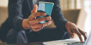 A Man Using A Laptop Computer Sitting On Top Of A Table