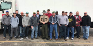 A Group Of People Standing In Front Of A Crowd Posing For The Camera