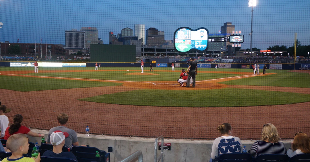 a group of people sitting around a baseball field