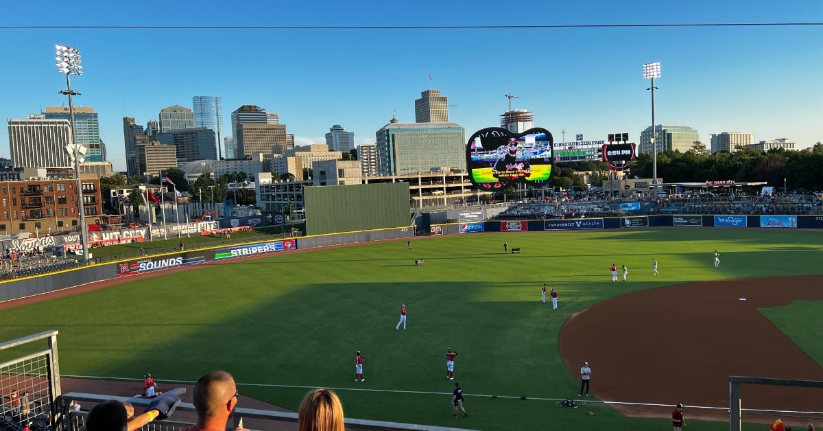 a group of people sitting around a baseball field