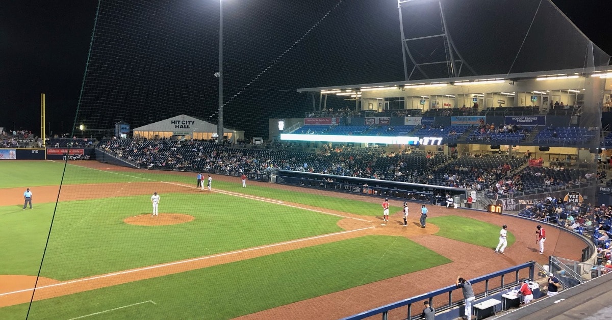 a group of people sitting around a baseball field